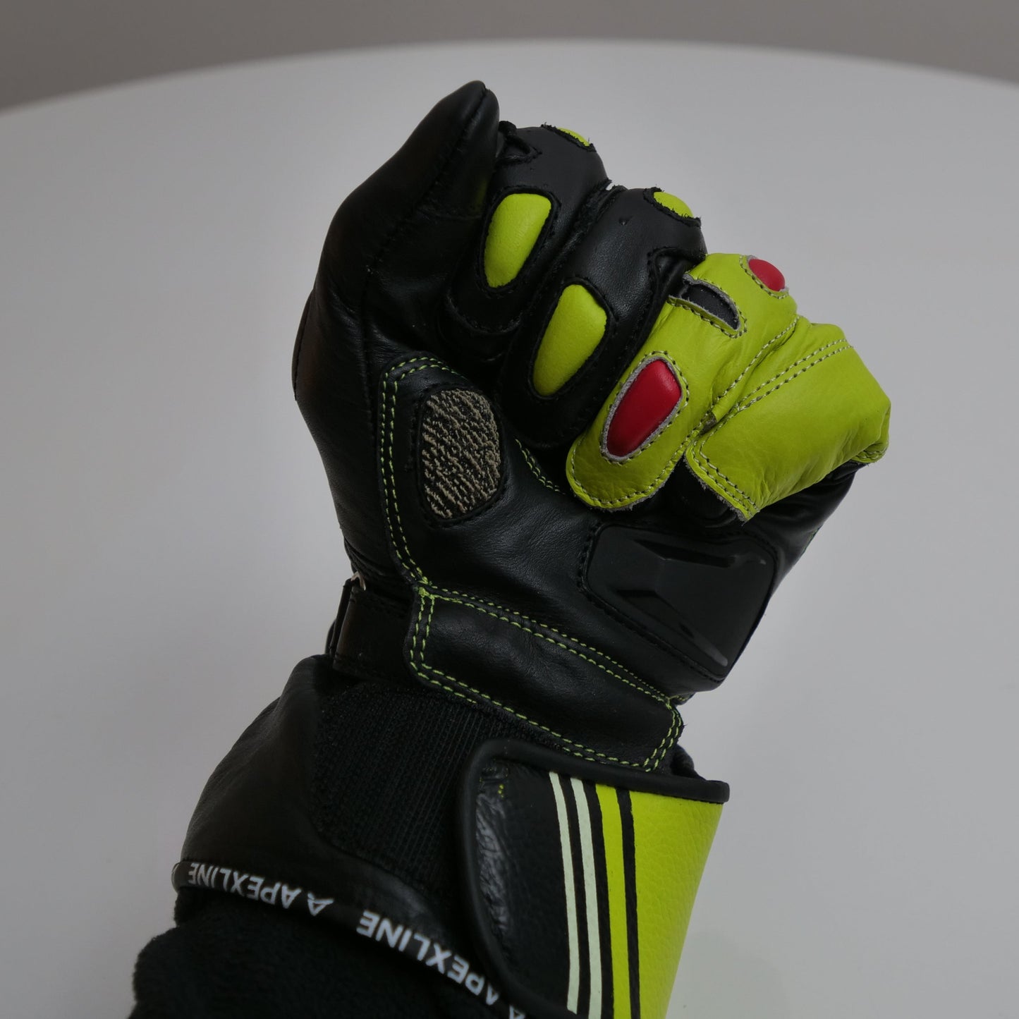 APEXLINE-Handschuh mit geschlossener Faust, zeigt Protektoren, Farbkontraste und anatomische Form.